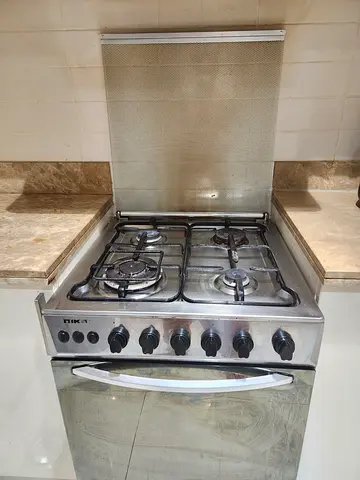Used stainless steel 4-burner gas stove with oven