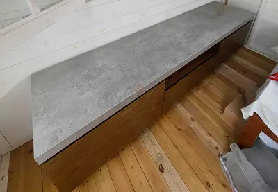 Long low wooden entertainment TV cabinet with concrete-look top