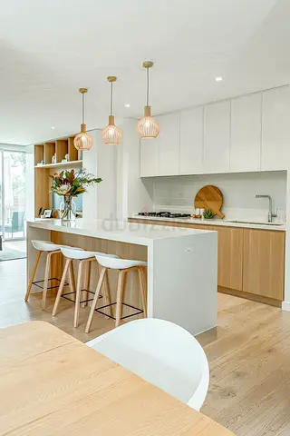 Modern kitchen island with pendant lights and stools