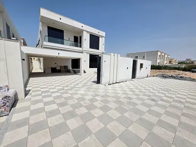 For sale, a villa in Al Rawda 2, Ajman, 5 bedrooms, a living room, two halls, a kitchen with a maid’s room, and a spacious yard.
