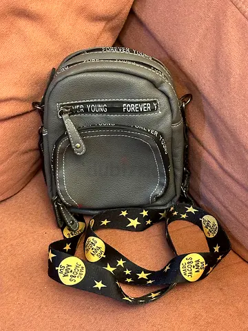 Small grey crossbody bag with detachable star-print strap