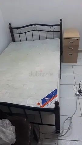 Single metal bed frame with mattress and bedside drawers
