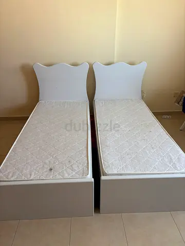 Pair of single beds with headboards and mattresses