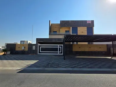 Modern villa for sale in Ajman, Al Helio area. 5 master bedrooms, 2 living rooms, majlis, kitchen, maid's room, and yard.