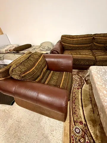 Brown leather-trimmed sofa and armchair set with patterned fabric cushions
