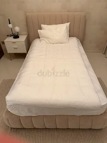 Single upholstered bed with padded headboard with mattress