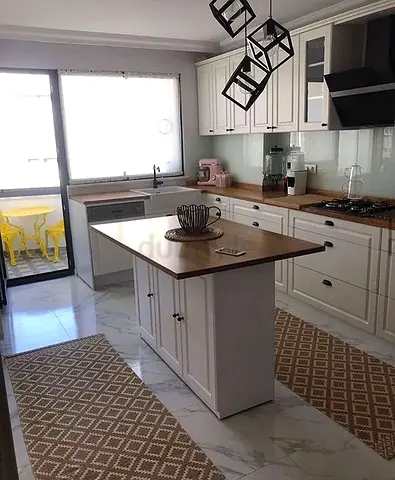 Modern white kitchen with central island and wooden countertops