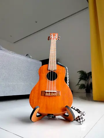 Concert ukulele in natural finish with strap