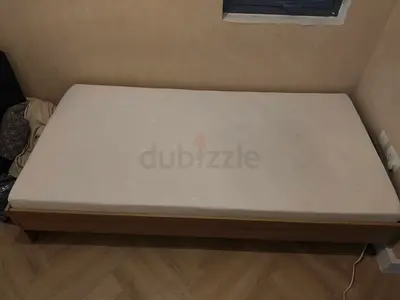 Single wooden bed frame with mattress - simple mid-century style.