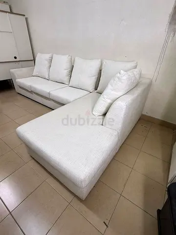 Light-colored sectional (L-shaped) sofa with comfortable back cushions