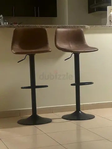 Pair of adjustable brown bar stools with swivel seats