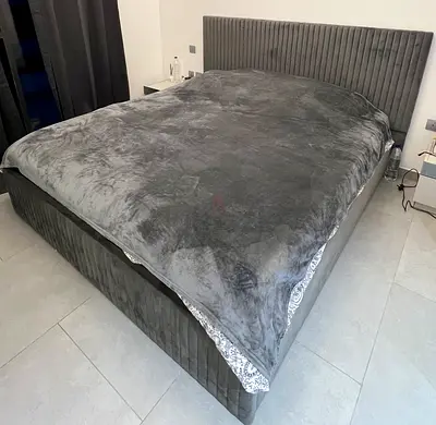 A bedroom set in excellent condition is for sale: a bed with mattress, two bedside tables, an ottoma