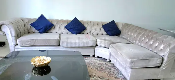 Light grey tufted L-shaped velvet sofa with cushions - good condition