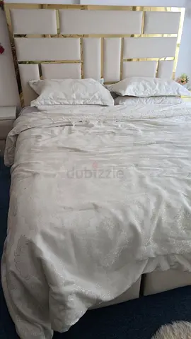 Queen-sized upholstered bed with padded headboard and storage base