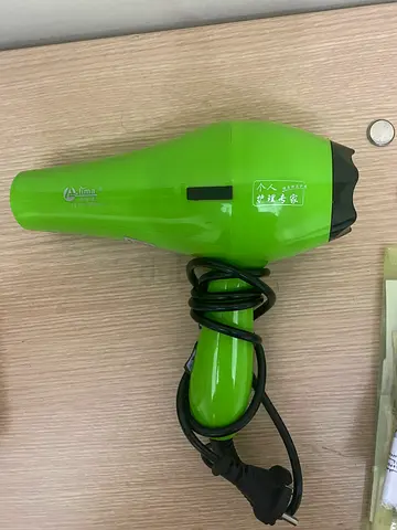Compact green hair dryer in good working condition