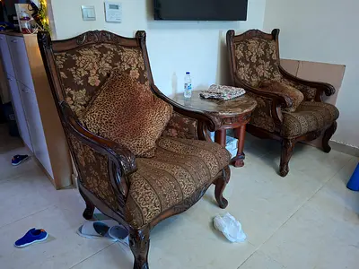 Pair of carved wooden armchairs with patterned upholstery