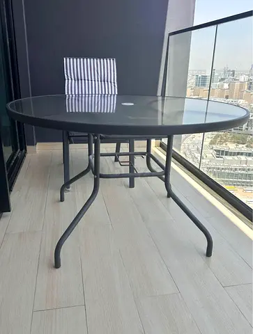 Description For Sale: Round Glass-Top Table Set  Includes: Four cushioned chairs and an unused umbre