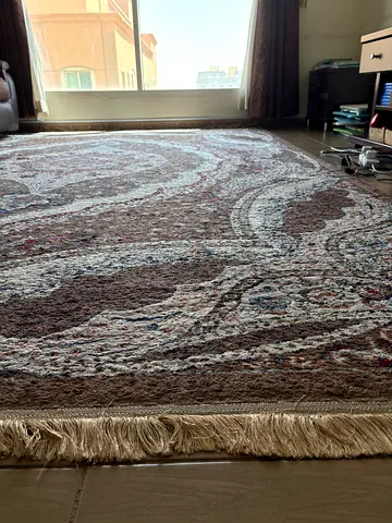 Large brown patterned Persian-style area rug with fringe