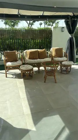 Rattan outdoor seating set — 1 double chair and 2 singles with cushions and 2 foot stools.