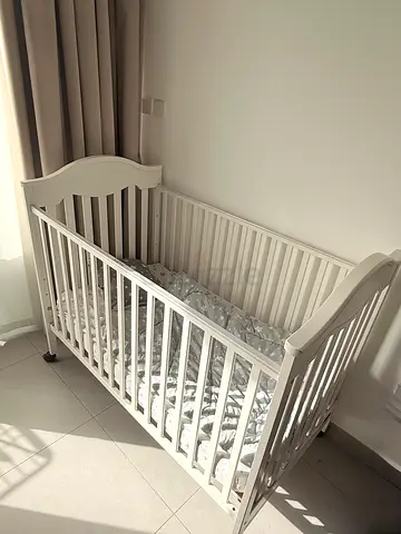 White wooden baby crib with wheels