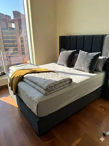 Grey upholstered double bed with tall padded headboard and luxury mattress - good condition