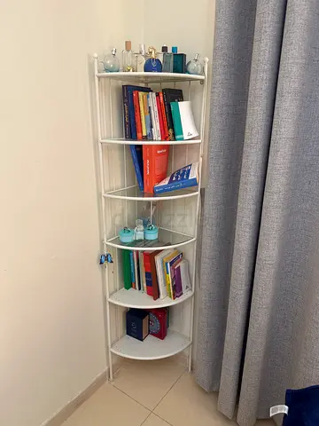 Small white corner bookshelf with assorted books and decor - good condition