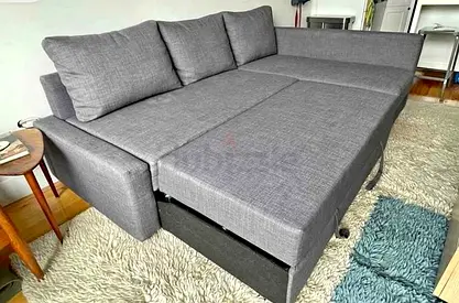 Grey L-shaped sofa bed (pull-out) in good condition