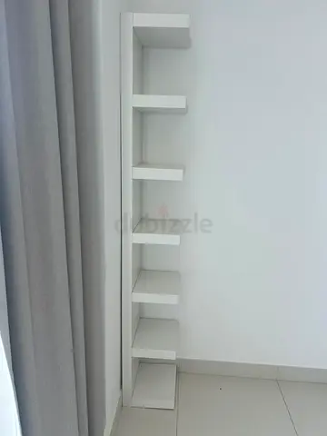 Slim white corner bookshelf with staggered shelves x2