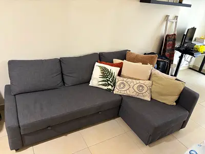 Dark grey L-shaped sofa with storage and cushions — good condition