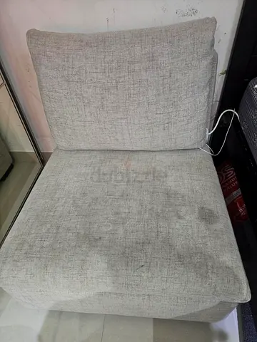 Light grey single armless lounge chair — used, some stains