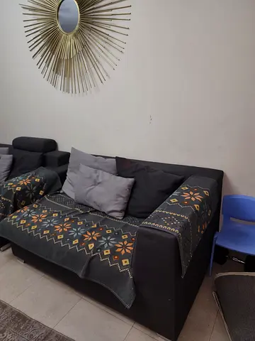 Dark grey  sofa with patterned throw covers - good condition