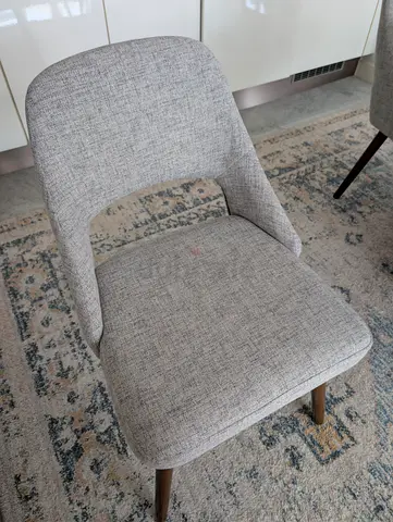 5 chairs for 1000 AED. Set of modern grey upholstered dining chairs with wooden legs (single shown)