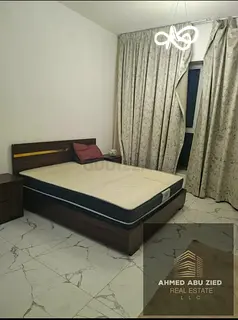 Furnished one-bedroom apartment with a living room in Al Waha Towers, Al Mina Street, opposite the f