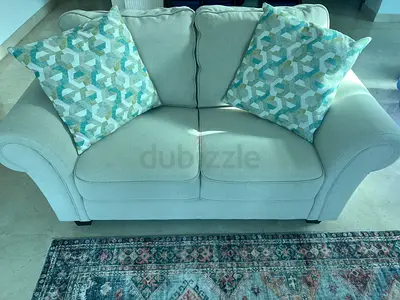 Light beige 2-seater sofa with patterned cushions