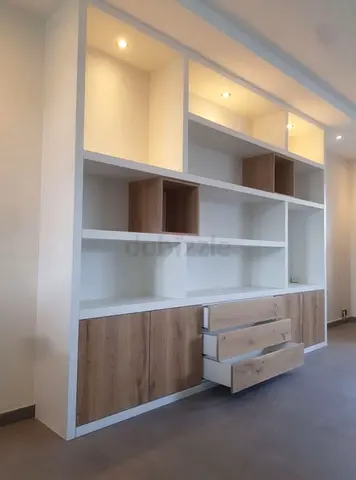 Custom built-in wall shelving unit with wooden doors and drawers