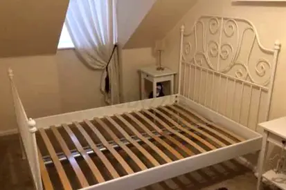 White metal queen bed frame with slatted base