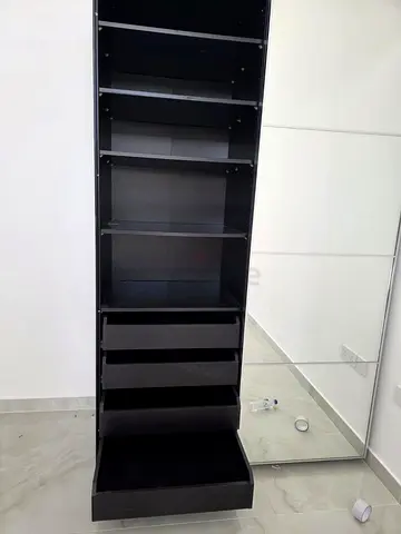 Tall black storage unit with drawers and shelves