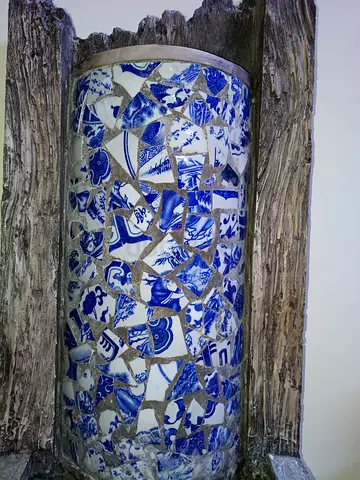Decorative blue-and-white ceramic mosaic vase in reclaimed wood frame