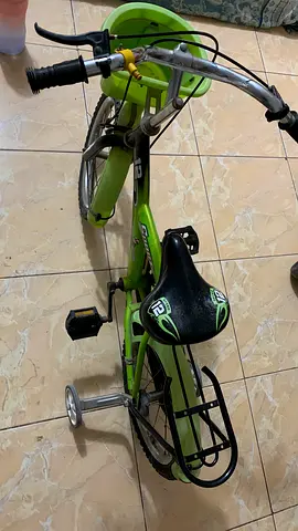 Kids green bicycle with training wheels and front basket