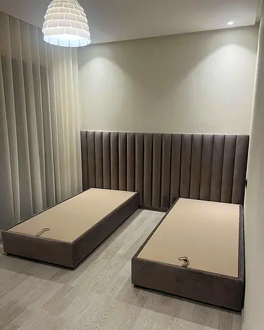 Pair of upholstered single bed frames with tall padded headboard