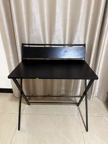 Compact black writing desk with storage shelf - good condition