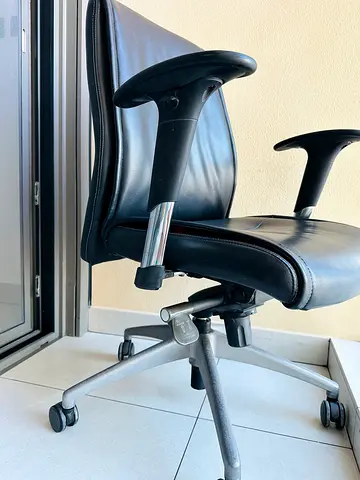 Black leather ergonomic office chair with armrests and wheels