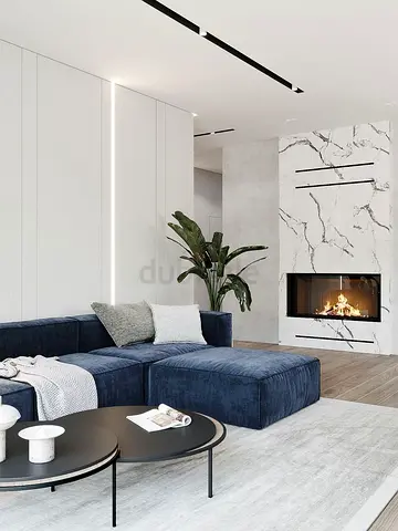 Blue velvet L-shaped sofa and marble fireplace unit