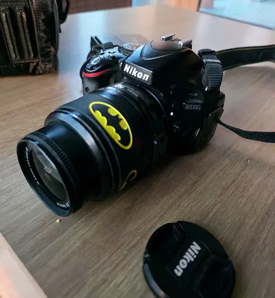 Nikon D5100 DSLR with 18-55mm VR lens (used) - Two batteries and chargers - Batman sticker