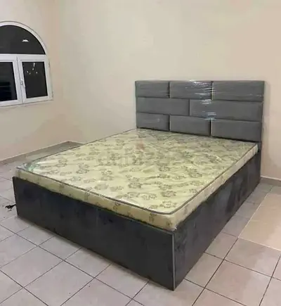 Gray upholstered double bed with storage base and headboard