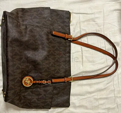 Micheal Kors, Brown leather tote handbag with zip closure and inner pockets.