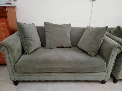Two-seater sofa in olive green with cushions