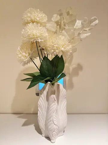 White artificial floral arrangement in textured ceramic vase