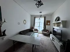 One-bedroom apartment with a living room and 2 bathrooms for annual rent, featuring a gym and swimmi