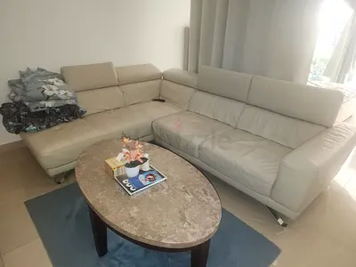 Home Centre Carrie faux leather beige corner sofa with adjustable headrests.